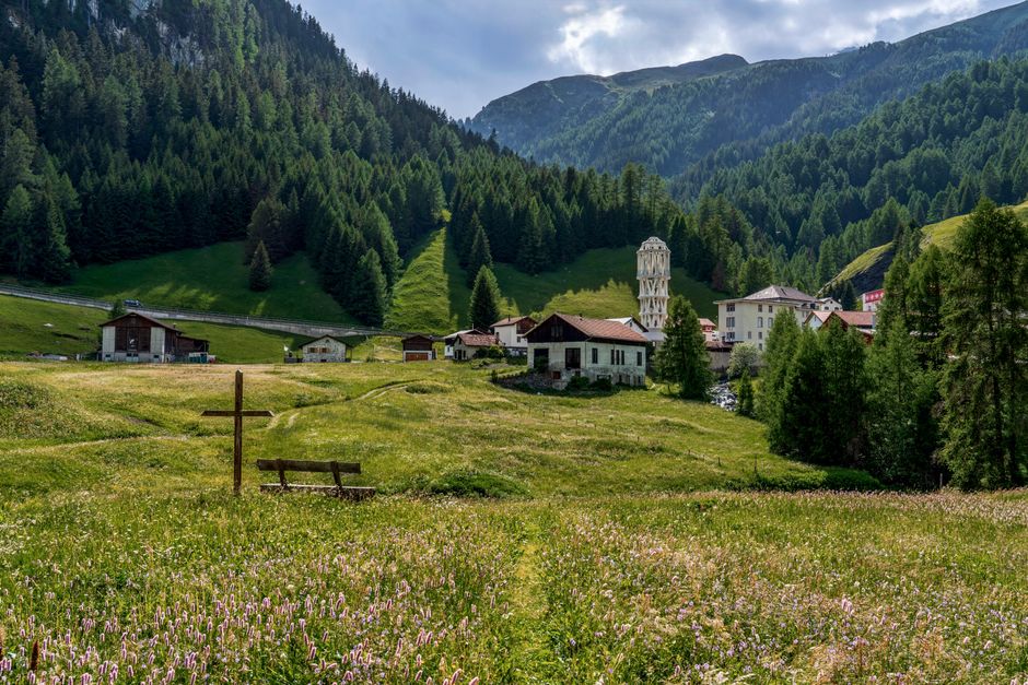 Scenic view of an Alpine village surrounded by lush meadows and mountains.